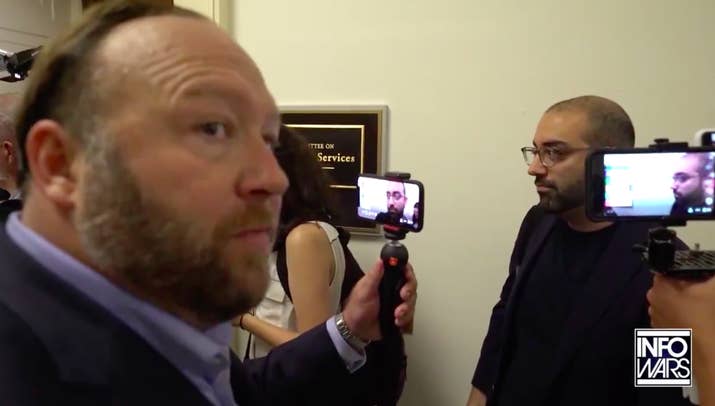 A still from Infowars video posted to Twitter of Jones confronting CNN reporter Oliver Darcy. The video was one of numerous violations that resulted in his suspension.