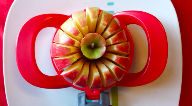 A reviewer&#x27;s apple being sliced into 16 even slices with the cutter