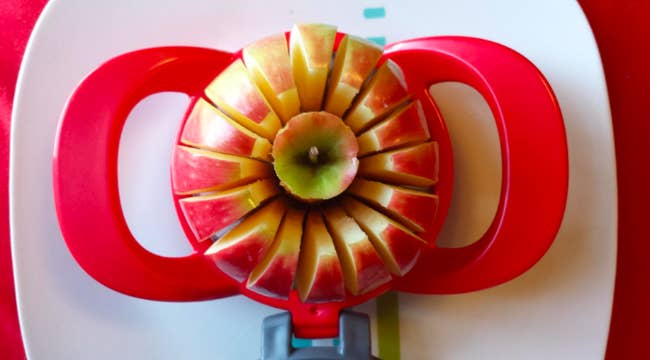 An apple being sliced into 16 even slices with the cutter