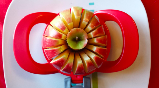 An apple being sliced into 16 even slices with the cutter