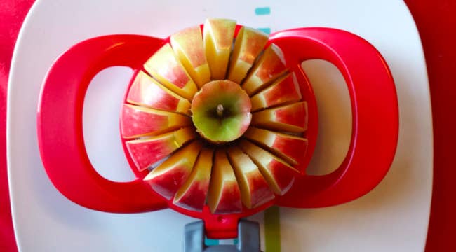 A reviewer's apple being sliced into 16 even slices with the cutter