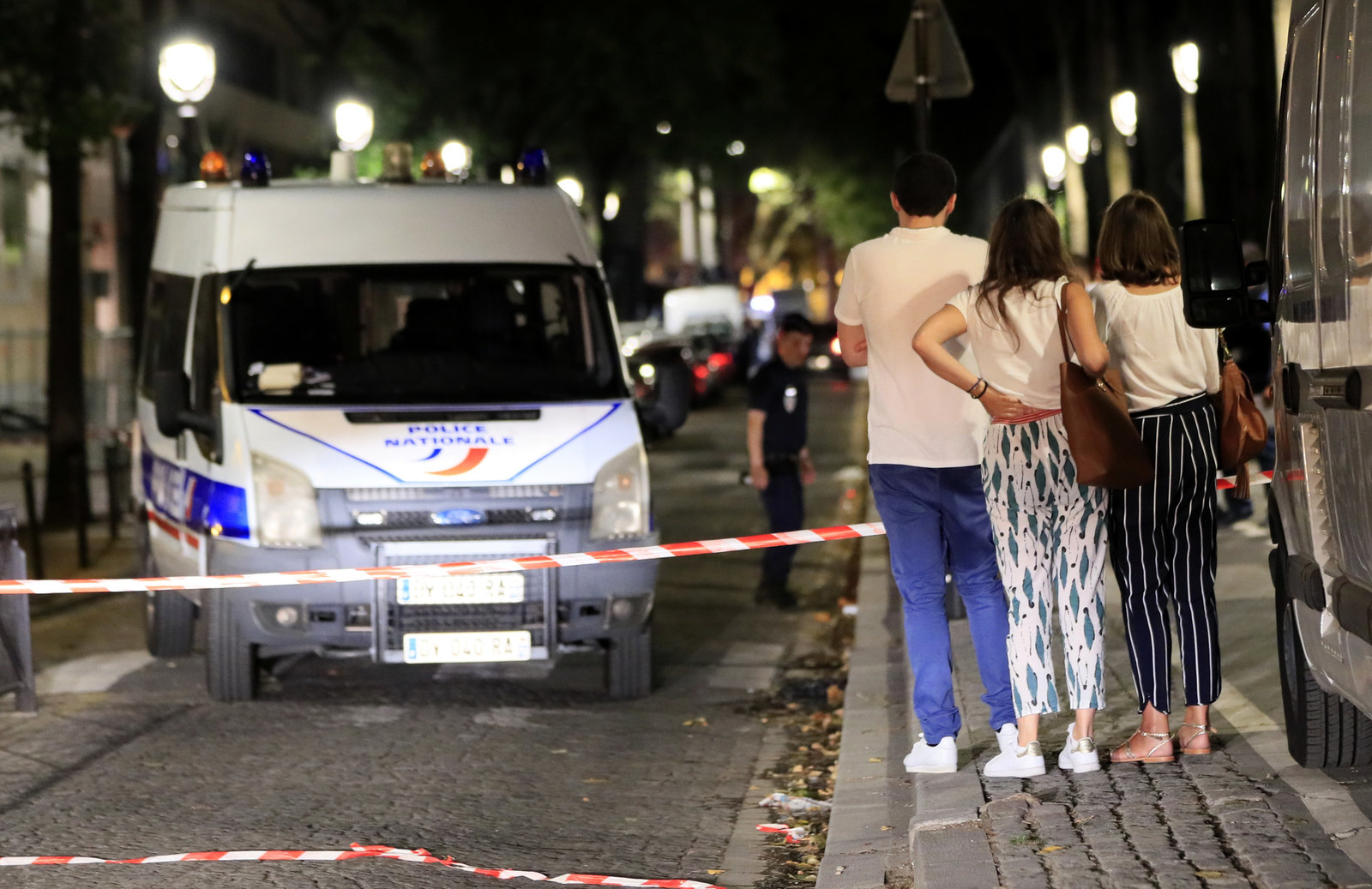 Police investigators work at the scene of a knife attack in downtown Paris that left seven people injured Sunday night.
