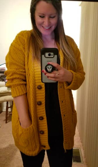 A reviewer wearing the cardigan in mustard yellow