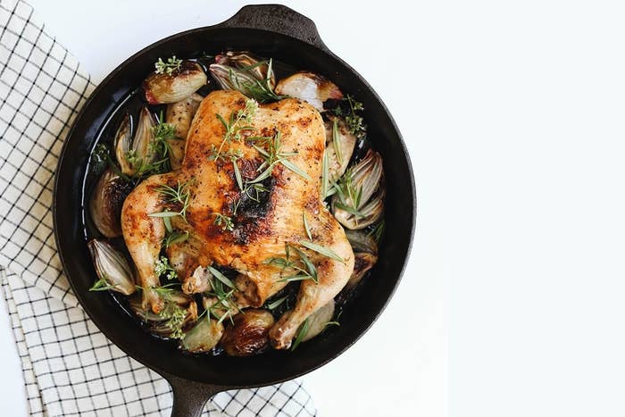 a cast iron pan with a roast chicken in it