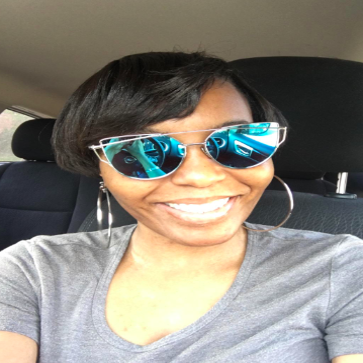 A reviewer wearing the sunglasses in silver with blue lenses