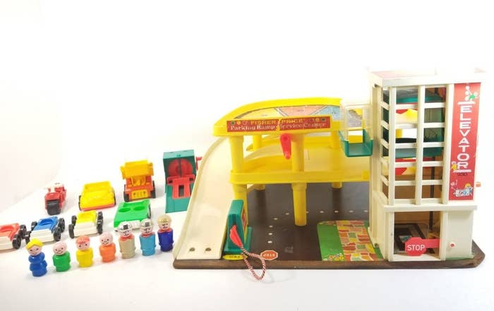 Fisher-Price Little People parking garage with a row of vintage Little People standing next to it