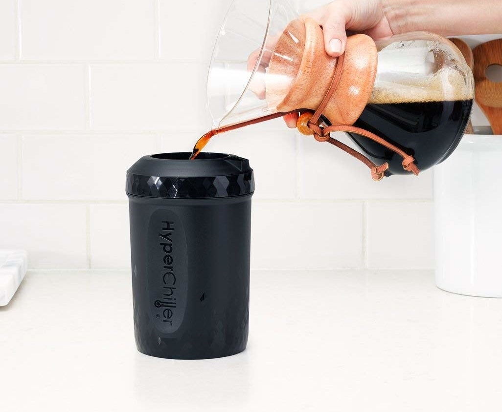 A hand pouring coffee from a pourover into the hyperchiller canister