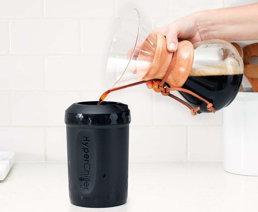 A hand pouring coffee from a pourover into the hyperchiller canister