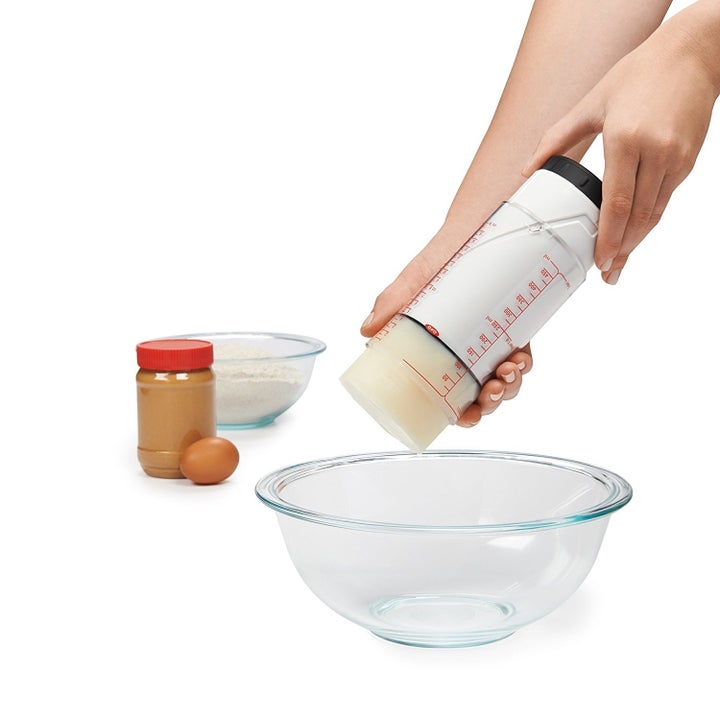 a hand using the measuring cup