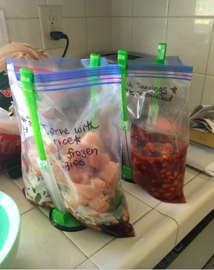 a customer review photo of plastic bags filled with leftovers being held up by the stackers