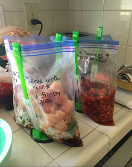 a customer review photo of plastic bags filled with leftovers being held up by the stackers