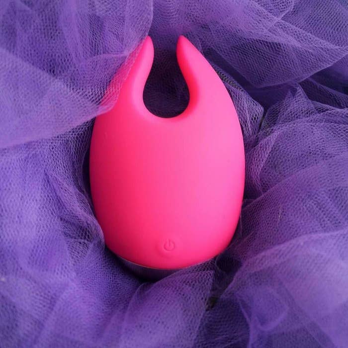 Pink clitoris vibrator with a curved shape