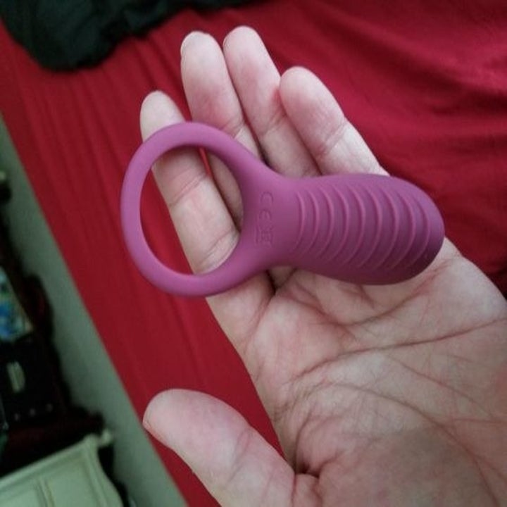 reviewer holds ring with long attachment thats about as long as a middle finger
