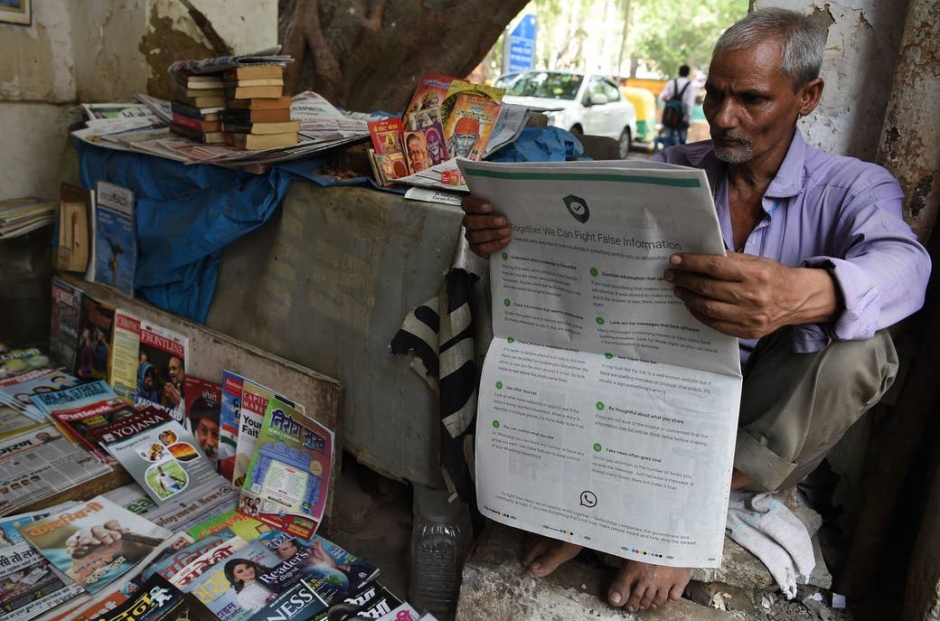 An Indian newspaper vendor reading a newspaper with a full backpage advertisement from WhatsApp intended to counter fake information, in New Delhi, on July 10, 2018.