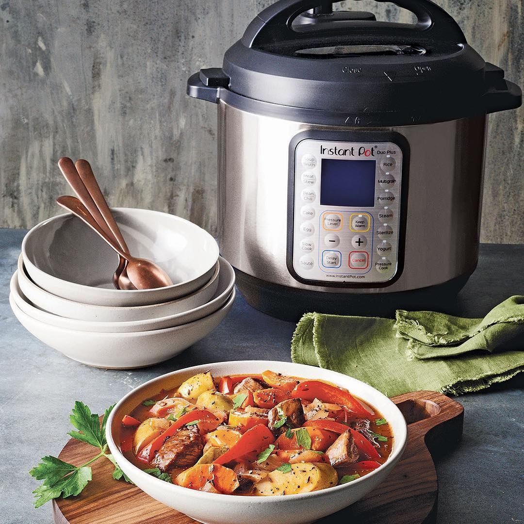 Instant Pot styled on table next to a bowl of soup