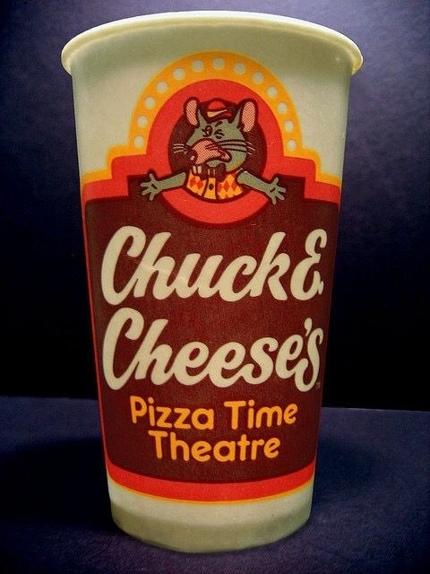 An orange and brown Chuck E. Cheese cup from the &#x27;80s with Chuck E. Cheese&#x27;s Pizza Time Theatre written on it