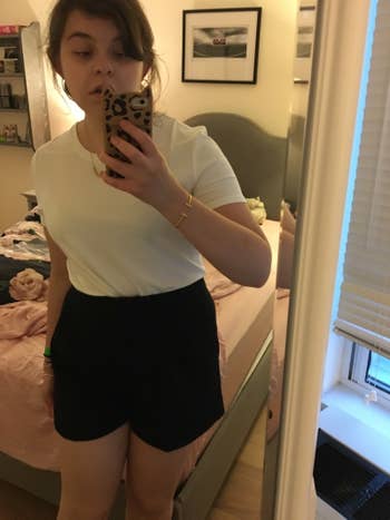 BuzzFeed Editor wearing the shirt tucked into a pair of black shorts