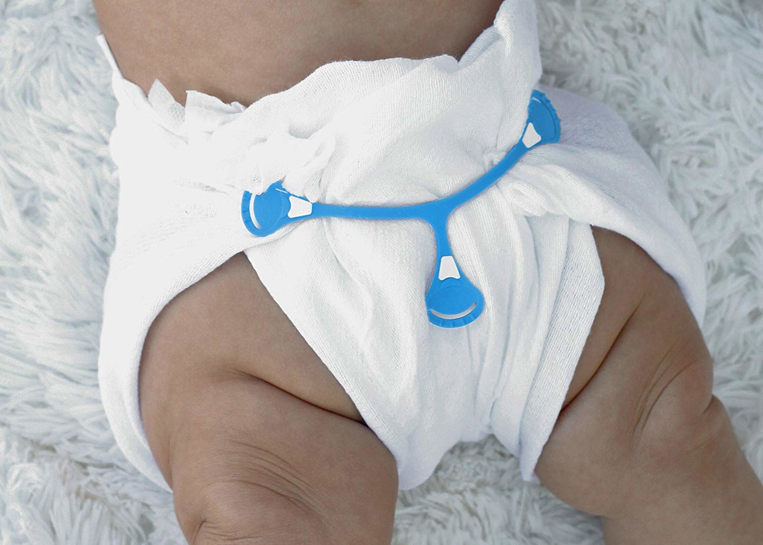 baby wearing a cloth diaper with the fastener holding it together