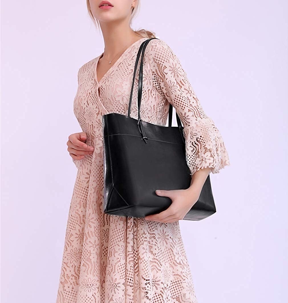 Model with the black rectangle-shaped tote bag over their shoulder