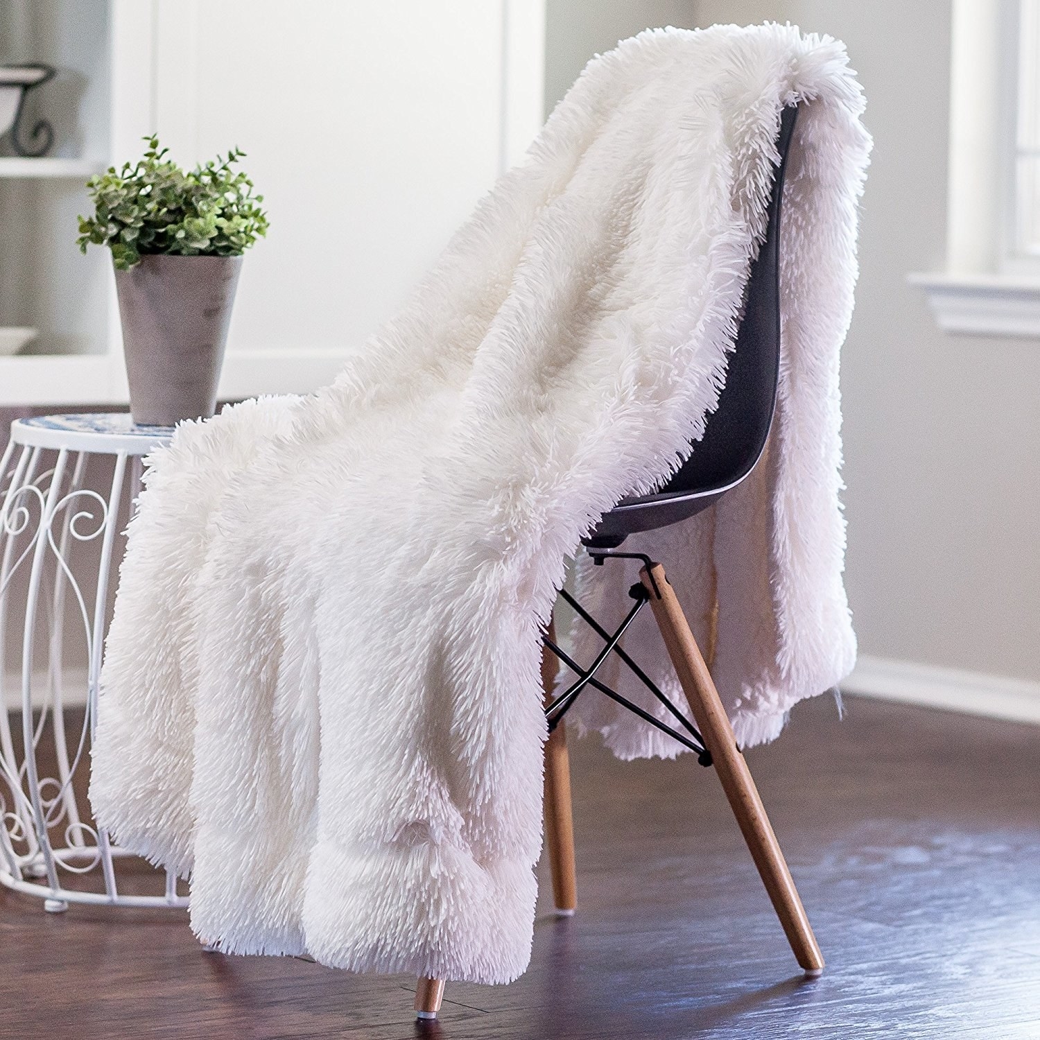 The fuzzy blanket in white sitting on a chair