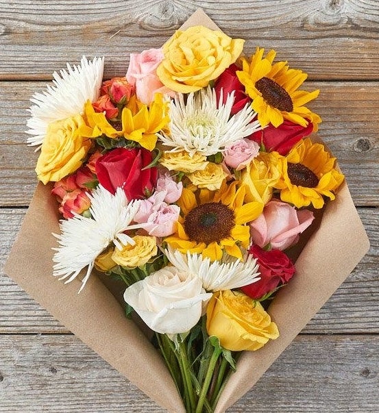 A bouquet of roses, spider mums, and sunflowers