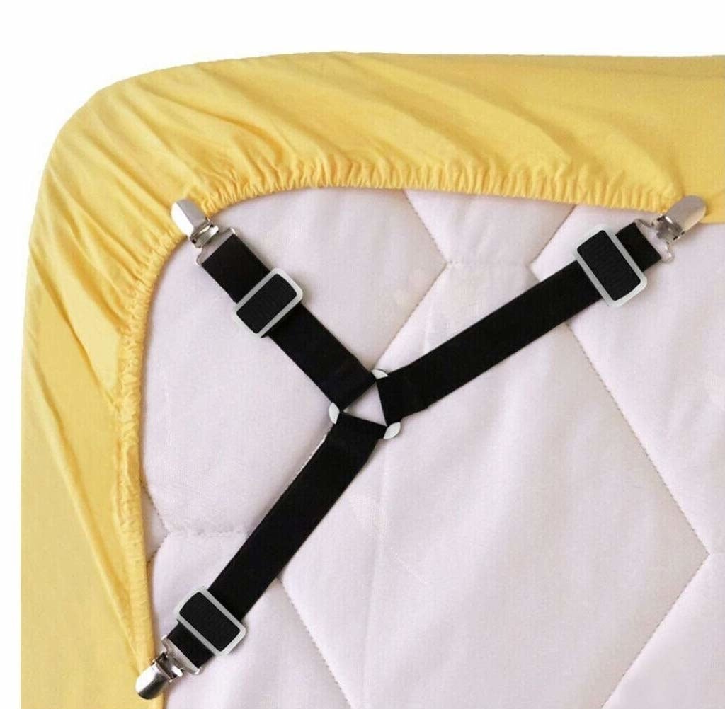 The suspenders securing a fitted sheet over the corner of the mattress