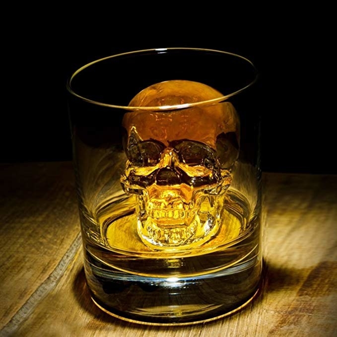 a skull-shaped ice cube made from the mold resting inside a glass