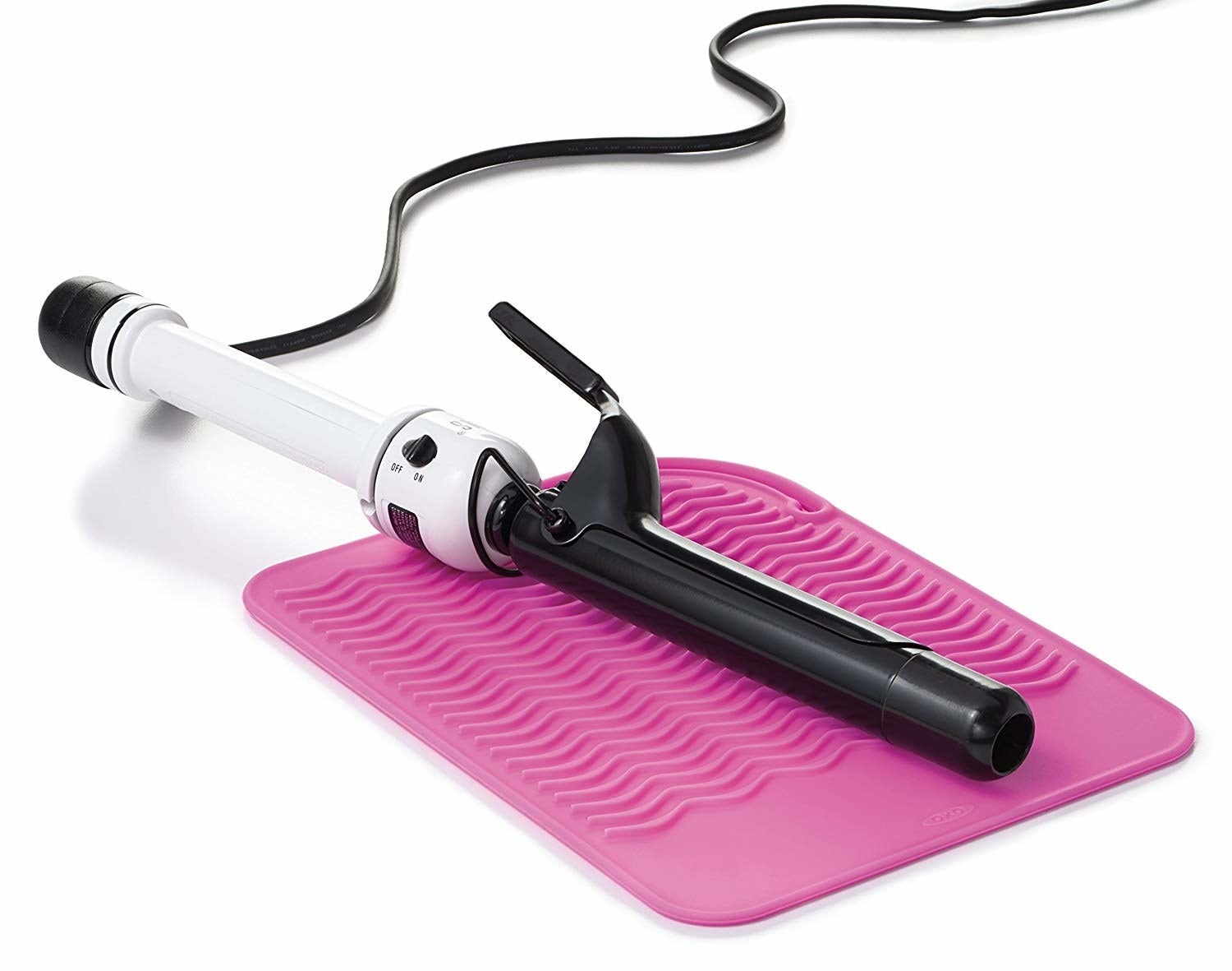 pink textured mat with a curling iron on it