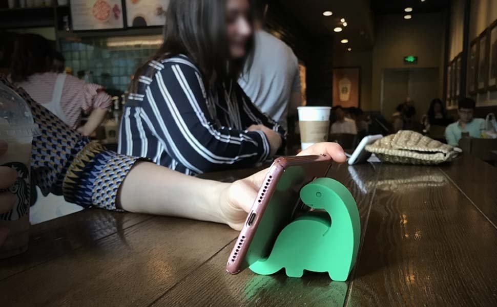person using the holder in a coffee shop to prop up phone
