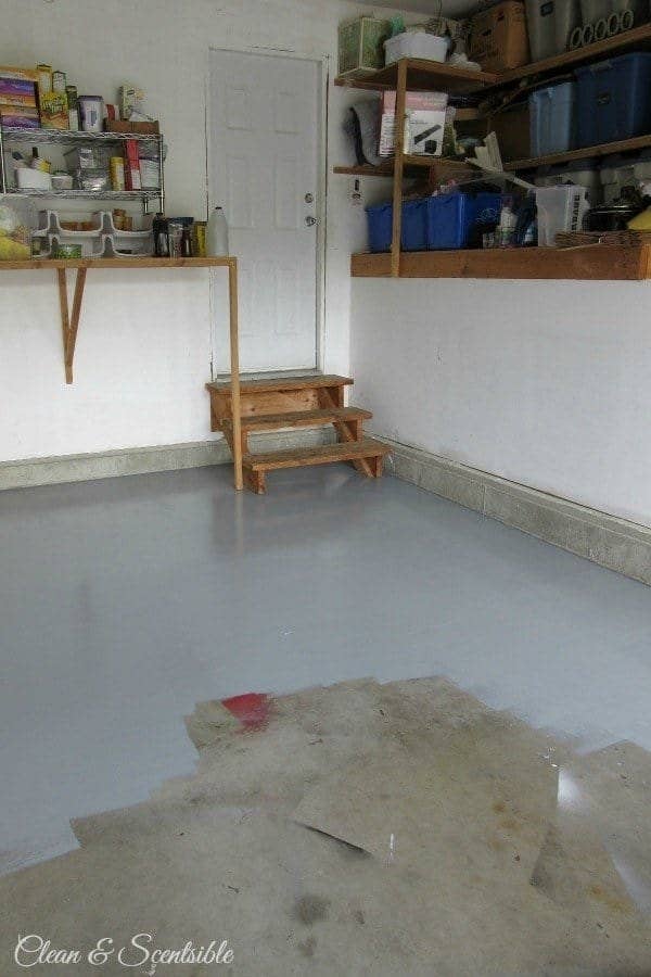 blogger&#x27;s garage floor, 75% covered in uniform grey paint that hides stains, spray paint overspray, and other mess on the concrete