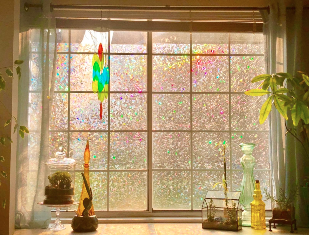 A reviewer&#x27;s big window covered in the film; the sunlight coming through causes the film to shine lots of different iridescent colors