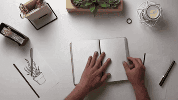 Gif of hands pulling pages out and adding them to another part of journal