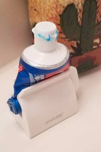 reviewer's photo of their toothpaste in the white holder