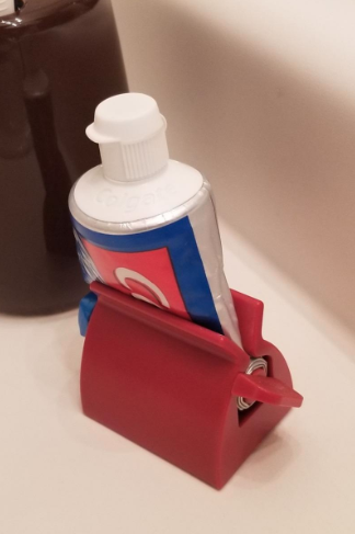 reviewer's photo of their toothpaste in the red holder 