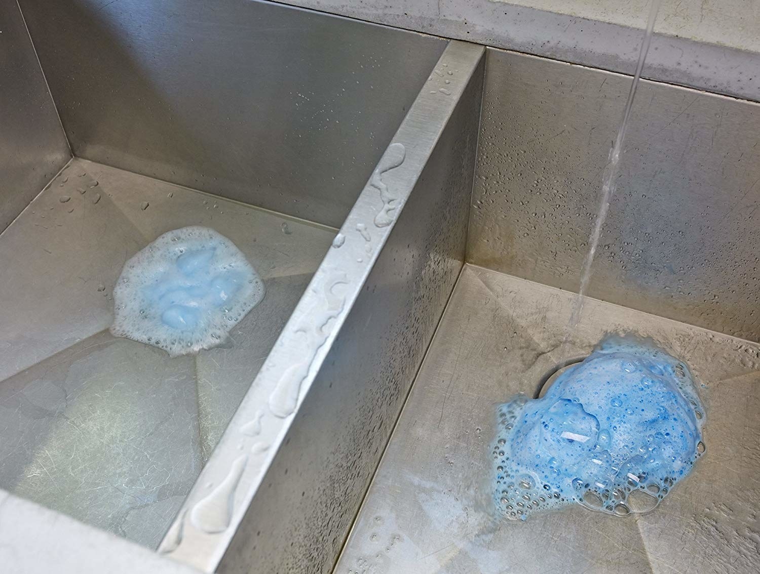 A drain with blue foaming bubbles inside