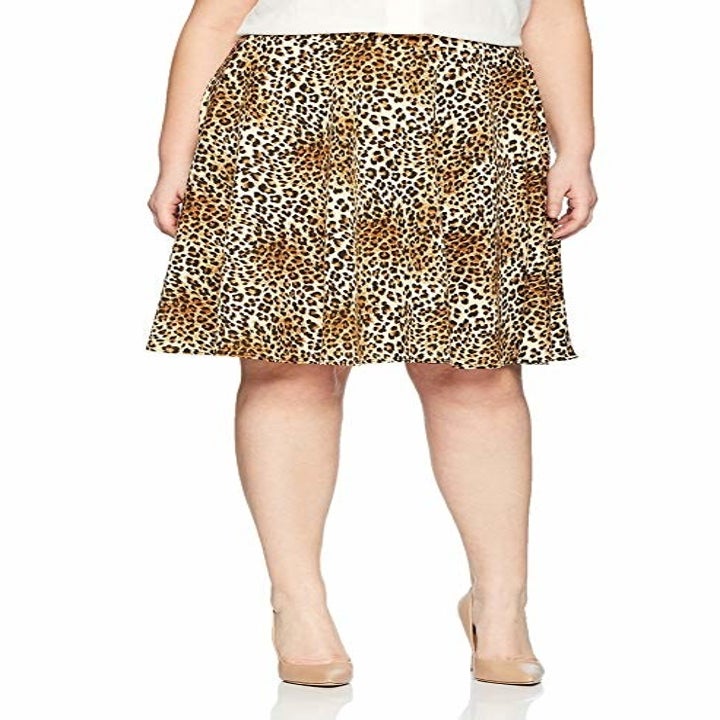 A model wearing the leopard print skirt that hits just above the knee