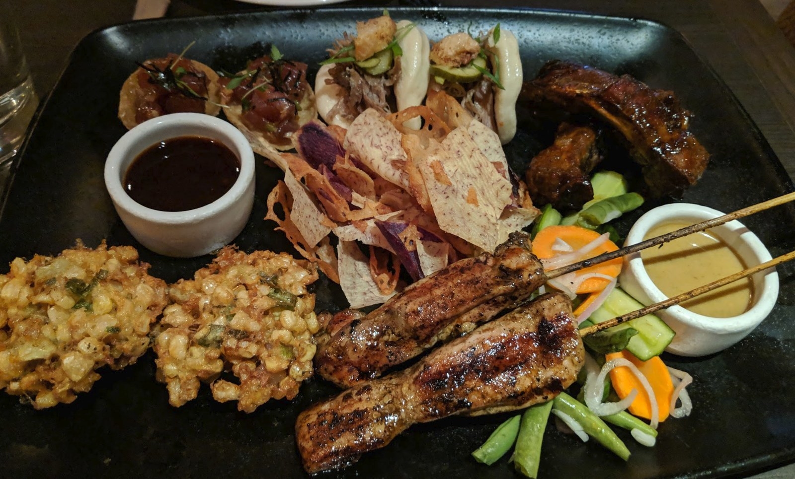 If time allows, try to visit E&O during Happy Hour (3-6PM) so you can order the amazing Pu Pu Platter, which features sampling of fan favorite appetizers, such as the Indonesian Corn Fritters, free-range chicken satay marinated in turmeric and lemongrass, tuna tartare bites, grilled baby back ribs in hoisin glaze, and steamed duck buns with crispy duck skin and five spice duck confit. The platter also includes taro chips and pickled veggies.