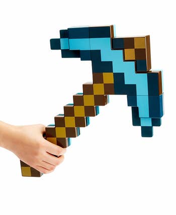 hand holding pixelated-looking pickaxe