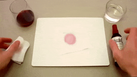 A gif of someone spraying a wine stain with the remover and it wiping out completely