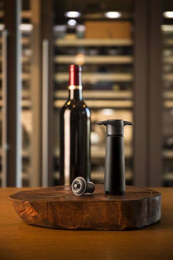 The wine waver and stopper next to a bottle of wine