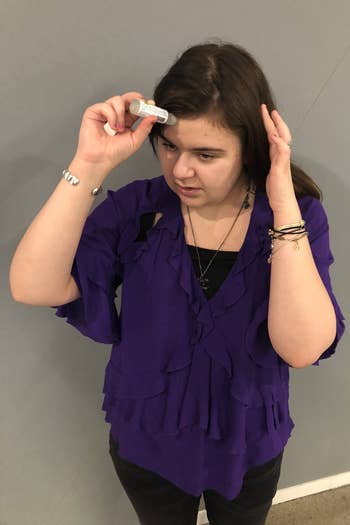 A BuzzFeed Shopping writer applying the stick to her forehead