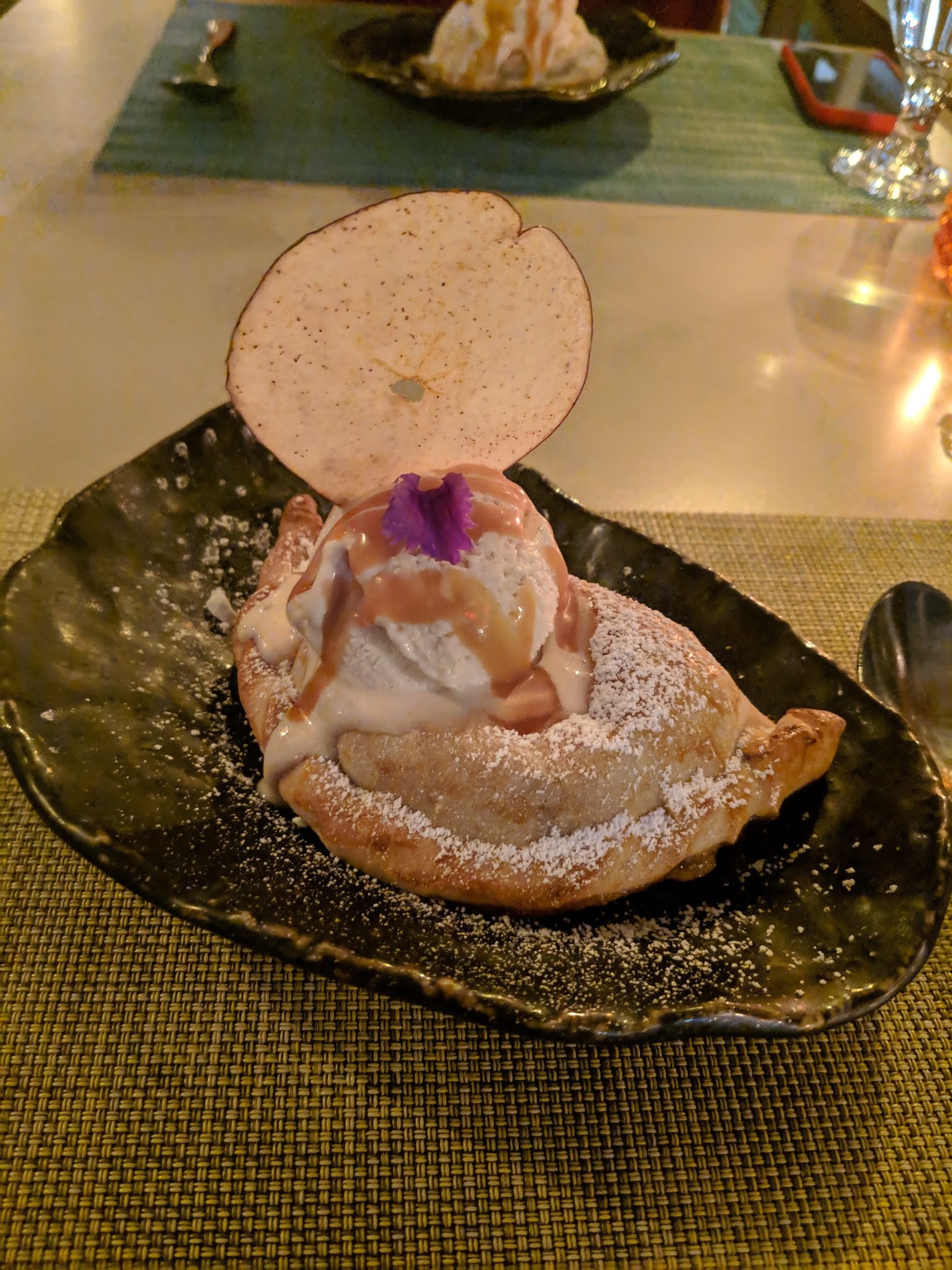 End the experience on a sweet note with this seasonal dessert of Baked Apple Empanada topped with pumpkin ice cream and a drizzle of sweet caramel sauce. The empanada is filled with delicious apple. The ice cream melts against the warm dough and the temperature balance between warm apple empanada and cold ice cream is absolutely divine.