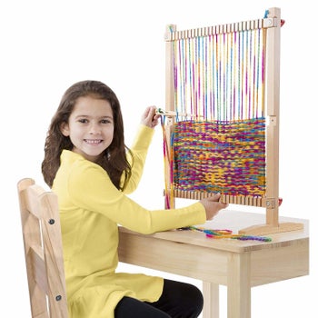 A model using the wooden loom that's sitting on a desk