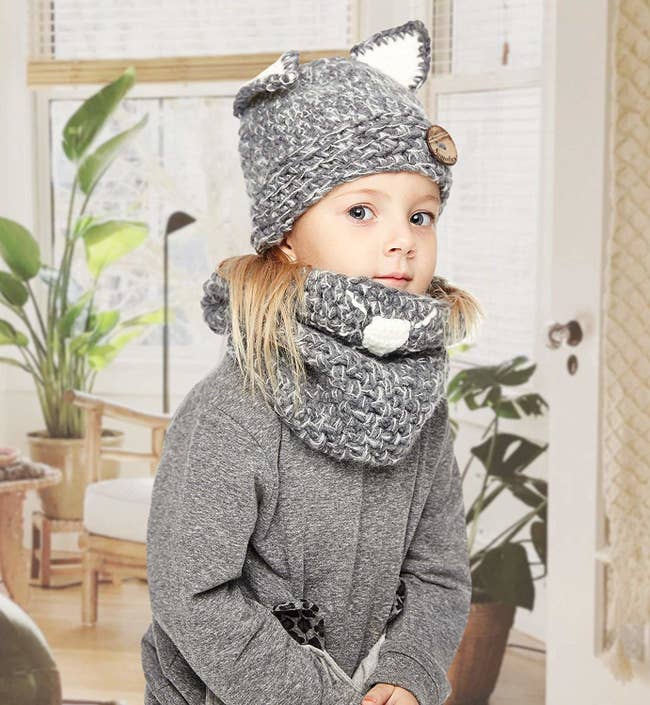 child model in grey scarf and hat with pointed animal ears