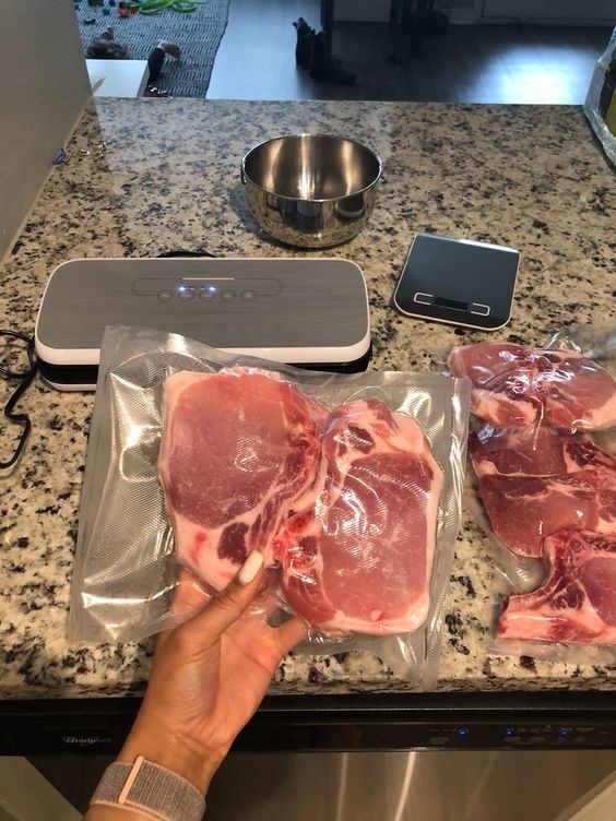 reviewer hand holding vacuum sealed meat