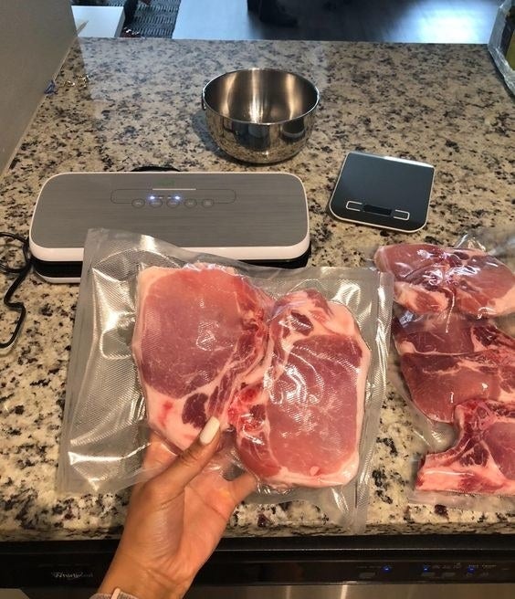reviewer hand holding vacuum sealed meat