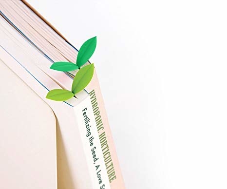 leaf-like bookmarks sticking out of the top of two books