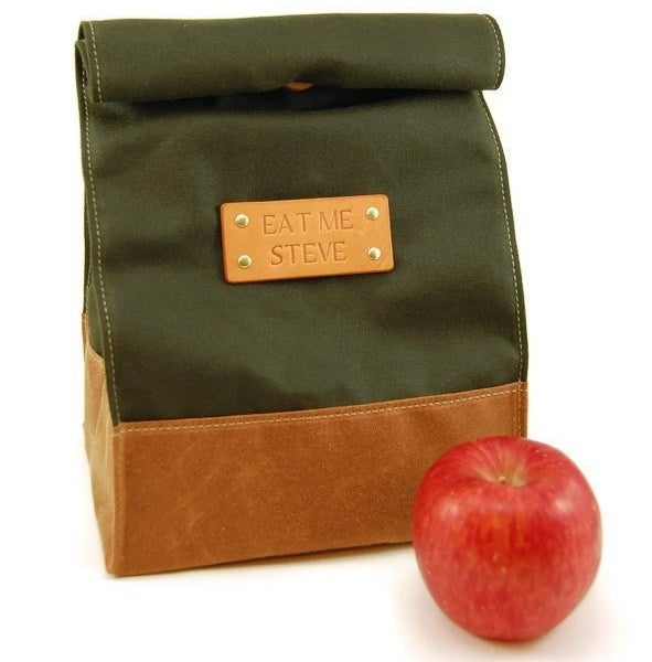 The leather and fabric roll-top lunch bag that says &quot;eat me steve&quot; on the nameplate
