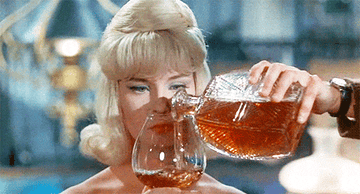 gif of a woman pouring whiskey from a decanter into a large glass