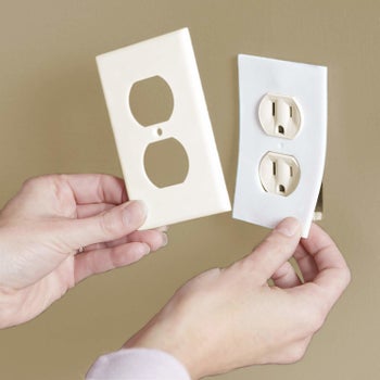 Hands installing one beneath a plug's plate